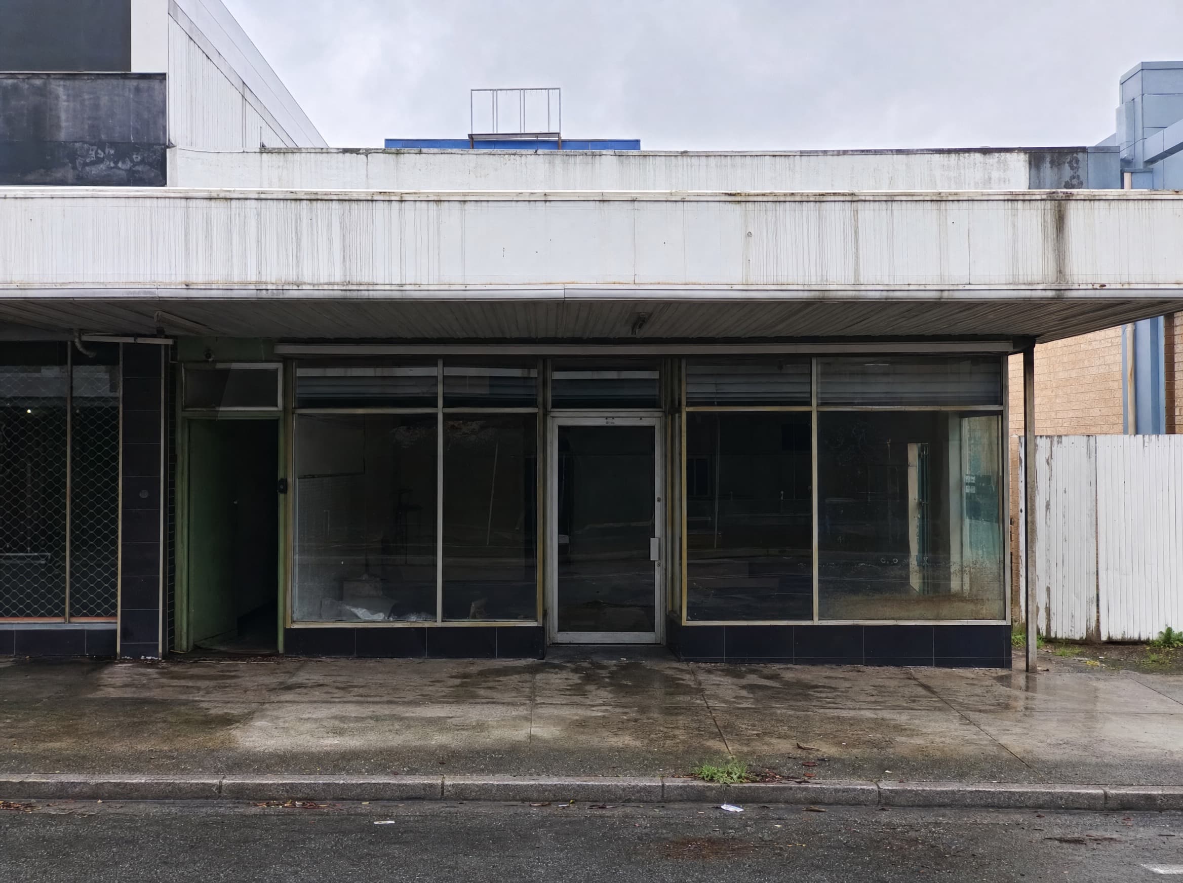 Grimy commercial shopfront before pressure washing in Hamilton, Newcastle